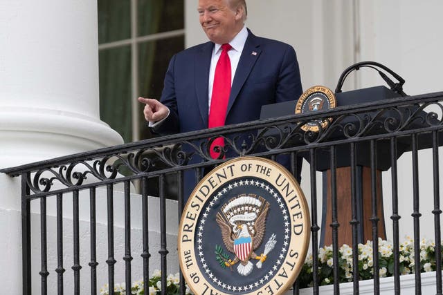 President Donald Trump points during a Rolling to Remember Ceremony to honour the nation's veterans and POW/MIA from the Blue Room Balcony of the White House on Friday 22 May 2020
