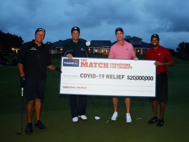 Tiger Woods and former NFL player Peyton Manning celebrate defeating Phil Mickelson and NFL player Tom Brady