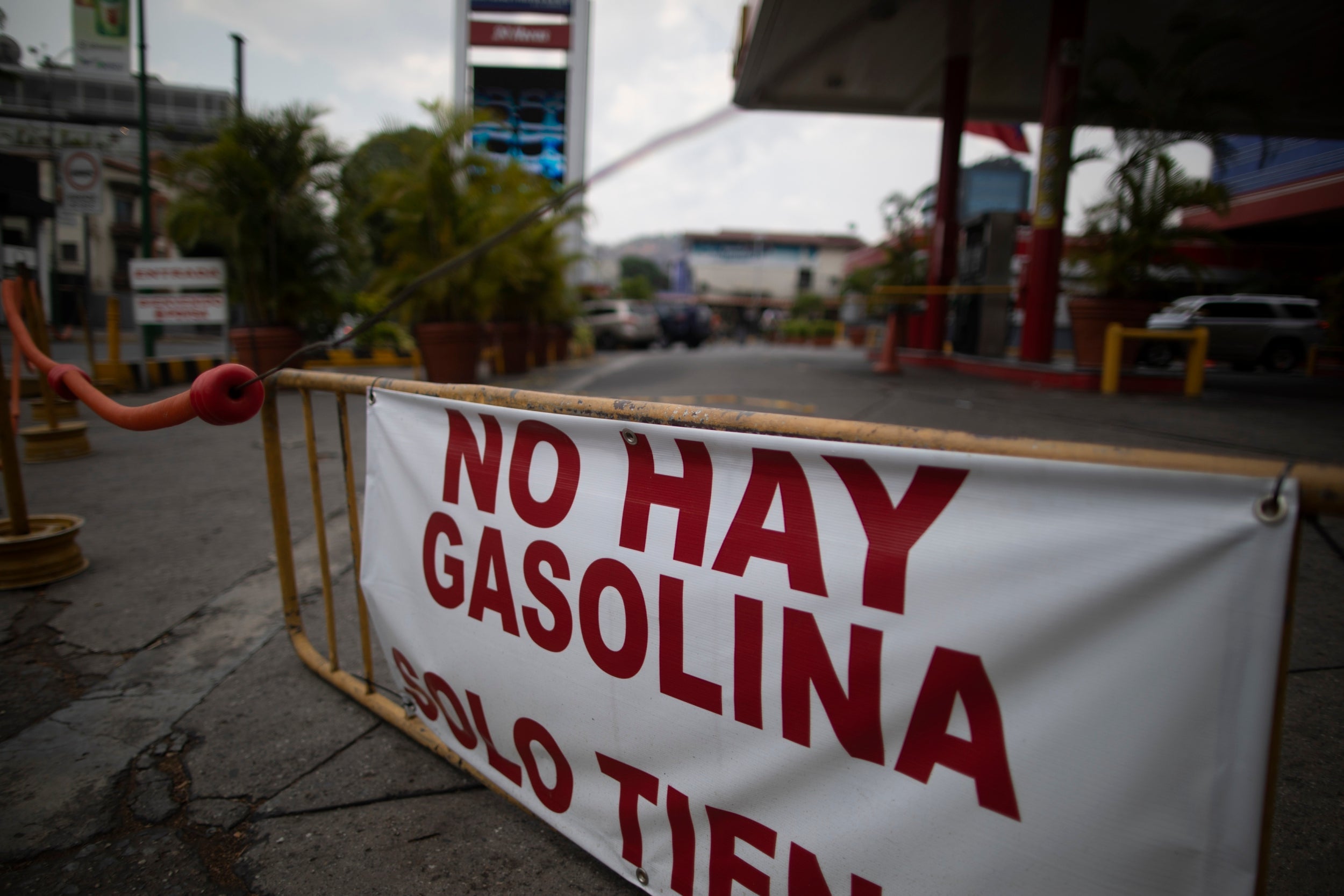 A banner reads, ‘There is no gasoline,’ outside a closed fuel station in Caracas, Venezuela