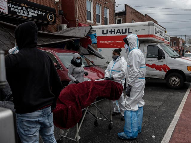 People in Hazmat suits transport a deceased body on a stretcher outside a funeral home in Brooklyn on April 30, 2020 in New York City. - Dozens of bodies have been discovered in unrefrigerated overflow trucks outside the Andrew T. Cleckley Funeral Home, following a complaint of a foul odor.