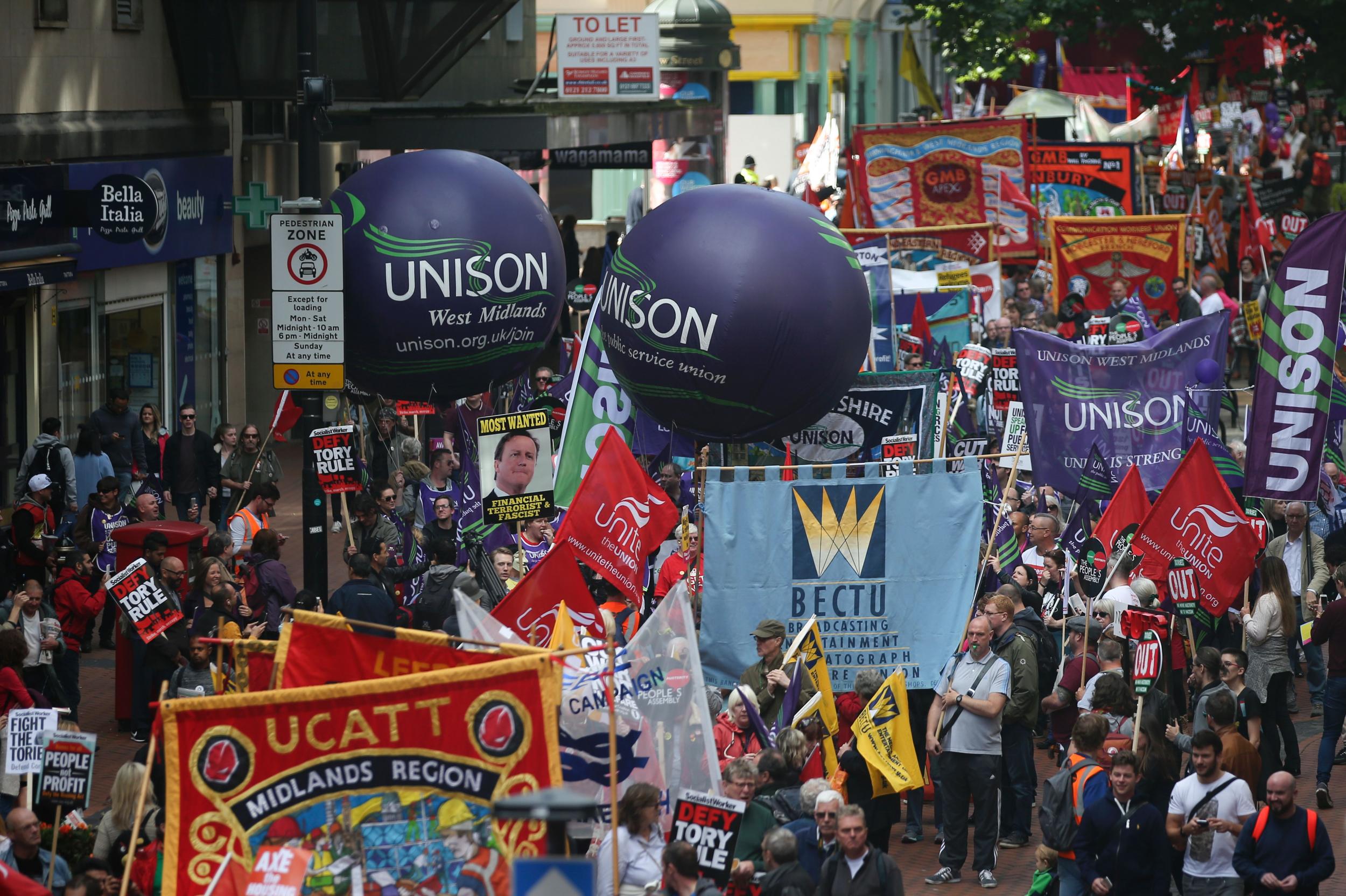 Anti-conservative protesters with placards and trade union banners march through Birmingham during Conservative party annual conference in 2016