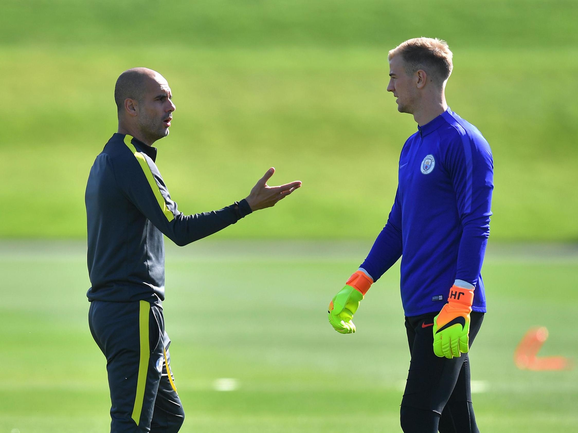 Manchester City manager Pep Guardiola talks to goalkeeper Joe Hart