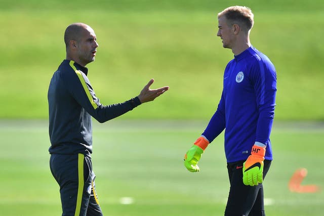 Manchester City manager Pep Guardiola talks to goalkeeper Joe Hart