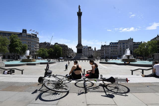 Cyclists take a break in the sunshine in Trafalgar Square after the introduction of measures to bring the country out of lockdown