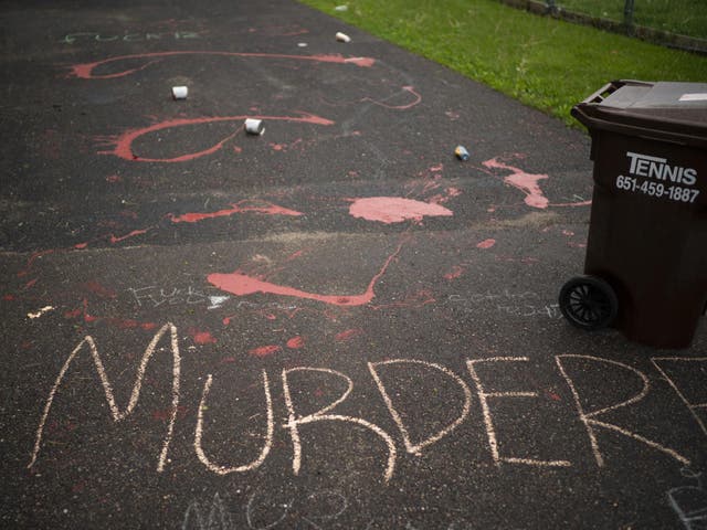 Splattered paint and chalk writing are on the driveway of the home of fired Minneapolis police Officer Derek Chauvin in Oakdale, Minn., Wednesday, May 27, 2020. The mayor of Minneapolis called Wednesday for criminal charges against Chauvin, the white police officer seen on video kneeling against the neck of Floyd George, a handcuffed black man who complained that he could not breathe and died in police custody.