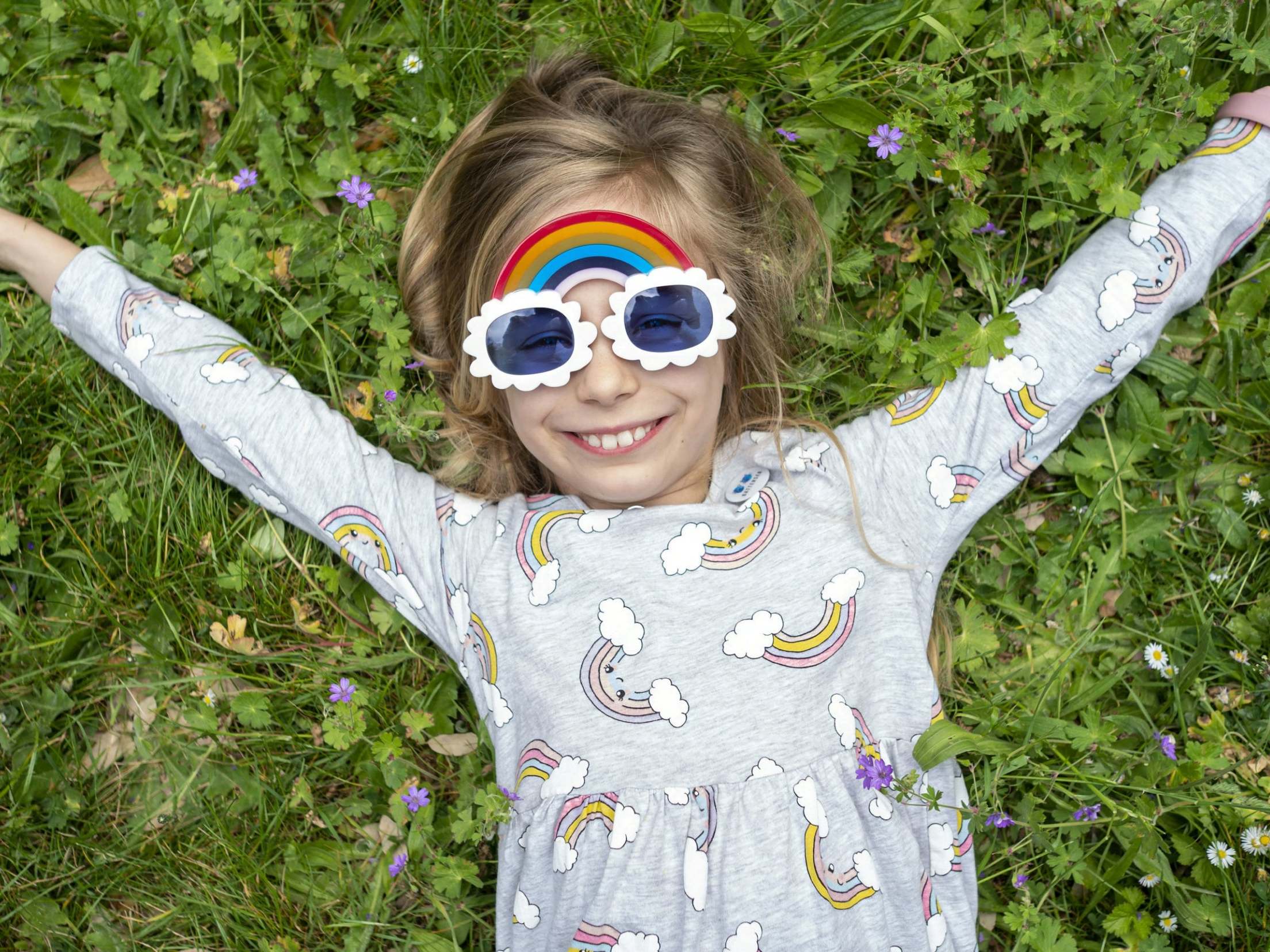 Schoolgirl Loa wears her rainbow sunglasses she made for NHS workers