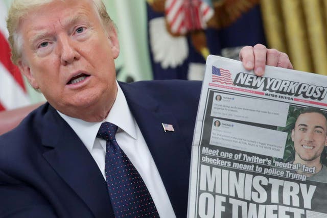 US president Donald Trump holds up a front page of the New York Post as he speaks to reporters while discussing an executive order on social media companies in the Oval Office of the White House in Washington, US, 28 May 2020.