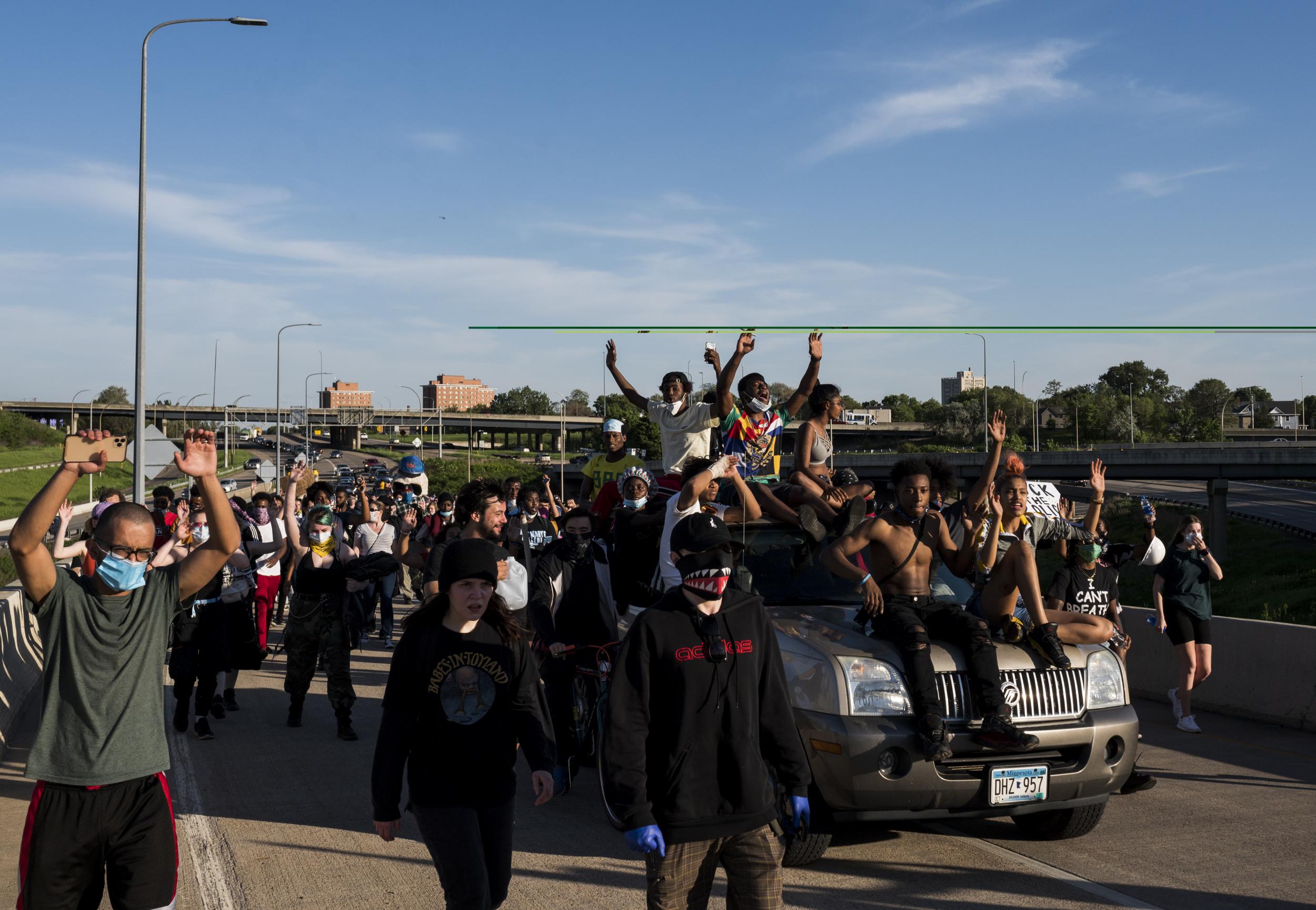 Protesters march down a highway off-ramp on their way to Minneapolis