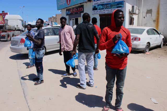 Migrants wait for food handouts in Misrata, Libya