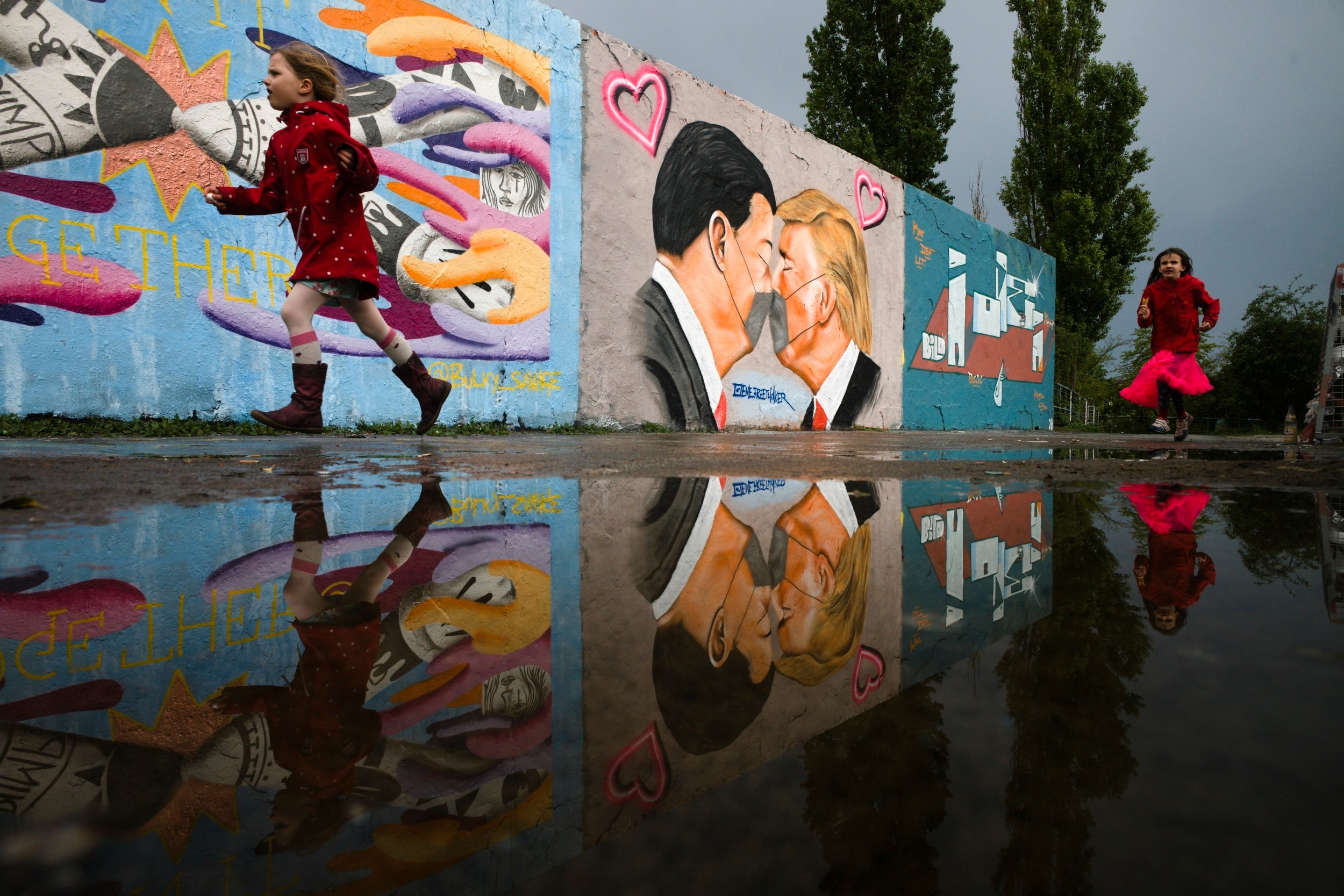 Graffiti of presidents Trump and Xi Jinping kissing each other through face masks on a wall in Berlin’s Mauerpark
