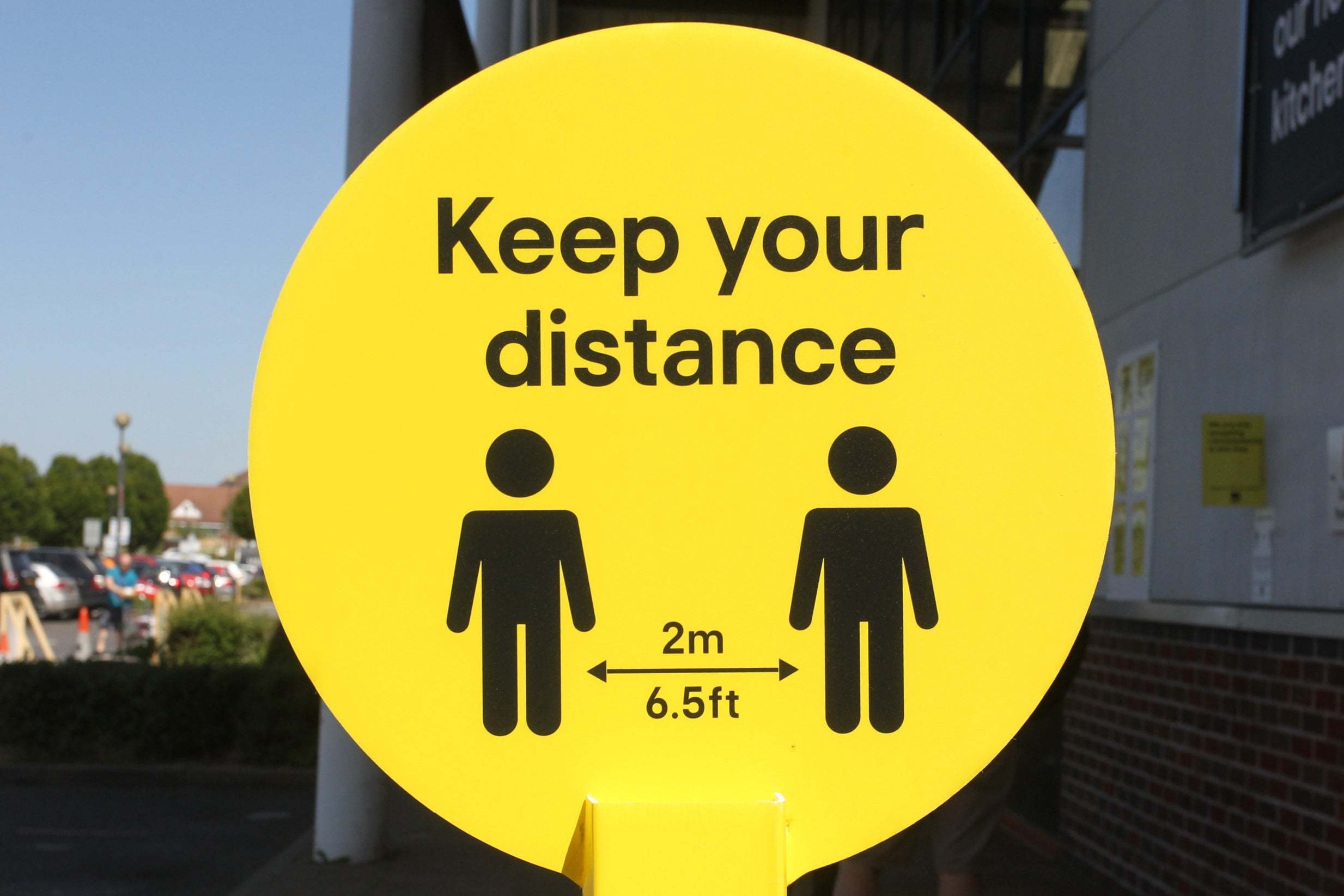 A sign reminds people to social distance