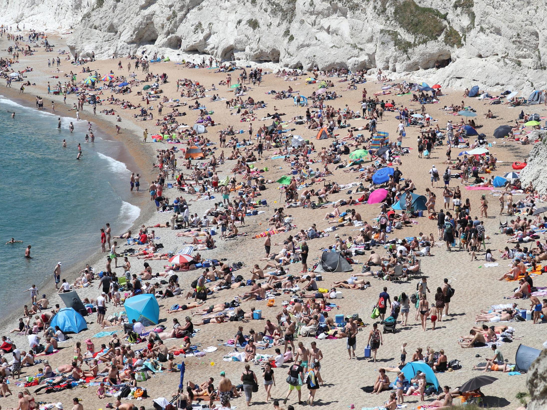 People fill the beach at Durdle Door, near Lulworth