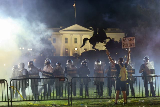 Police in riot gear stand between demonstrators and the White House during protests against law enforcement racism