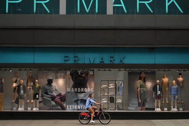 A woman cycles passed a shut Primark store on Oxford Street, London