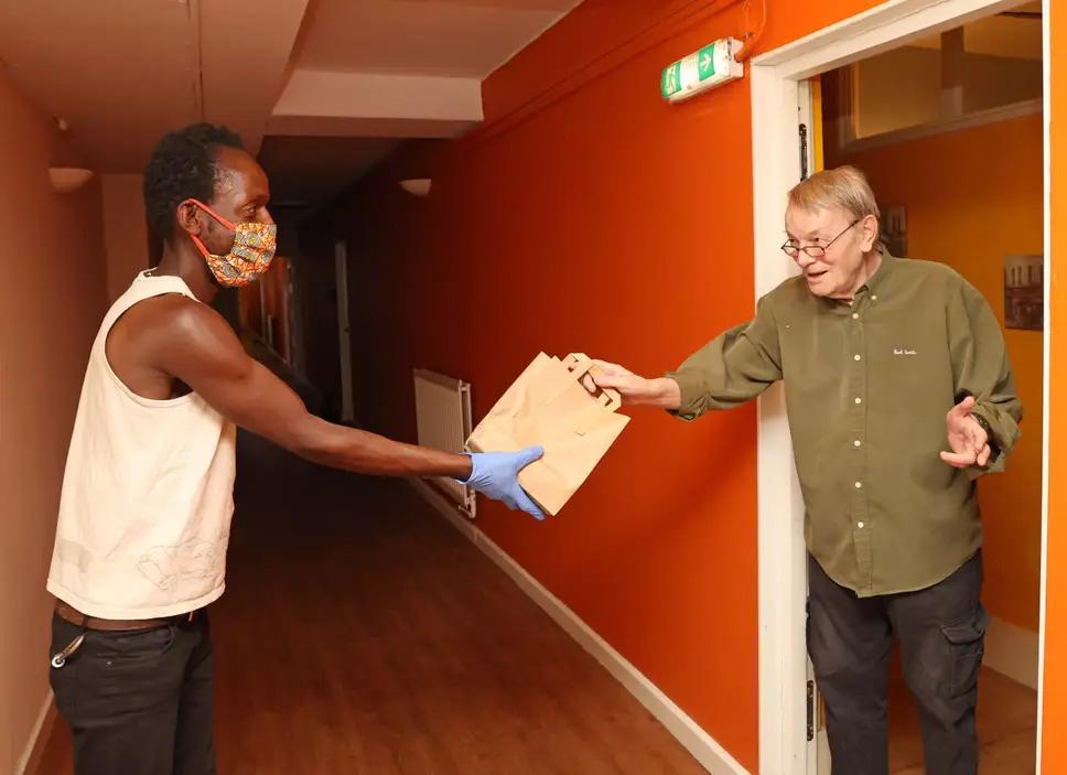 Received with thanks: Nigel Howat, 79, accepts his food parcel from Clarence Chodokufa