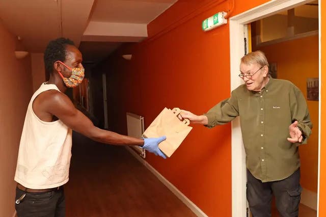 Received with thanks: Nigel Howat, 79, accepts his food parcel from Clarence Chodokufa