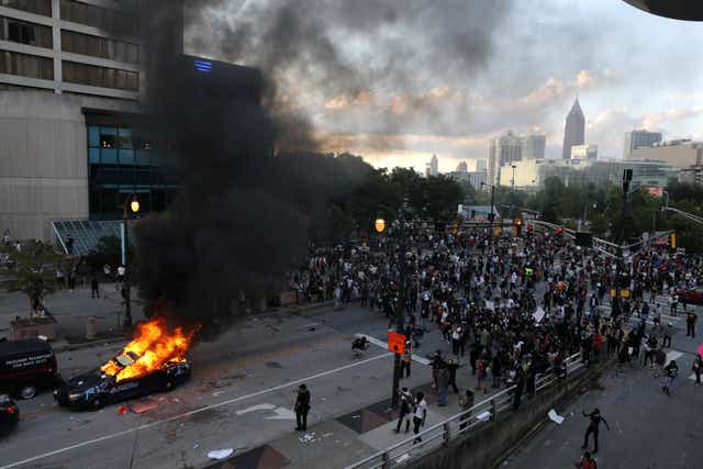 A police car burns in Atlanta during a protest over the death of George Floyd