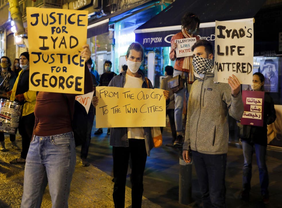 Israeli demonstrators carry placards during a demonstration condemning the shooting of Iyad Hallak, a disabled Palestinian man who was shot dead by Israeli police