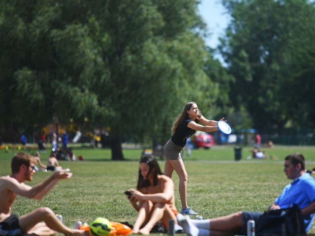 People enjoy the hot weather on Clapham Common, London, as people are being reminded to practise social distancing