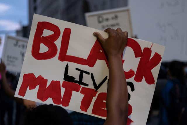 <p>A person holds up a placard that reads 'Black Lives Matter' during a protest in the city of Detroit, Michigan</p>