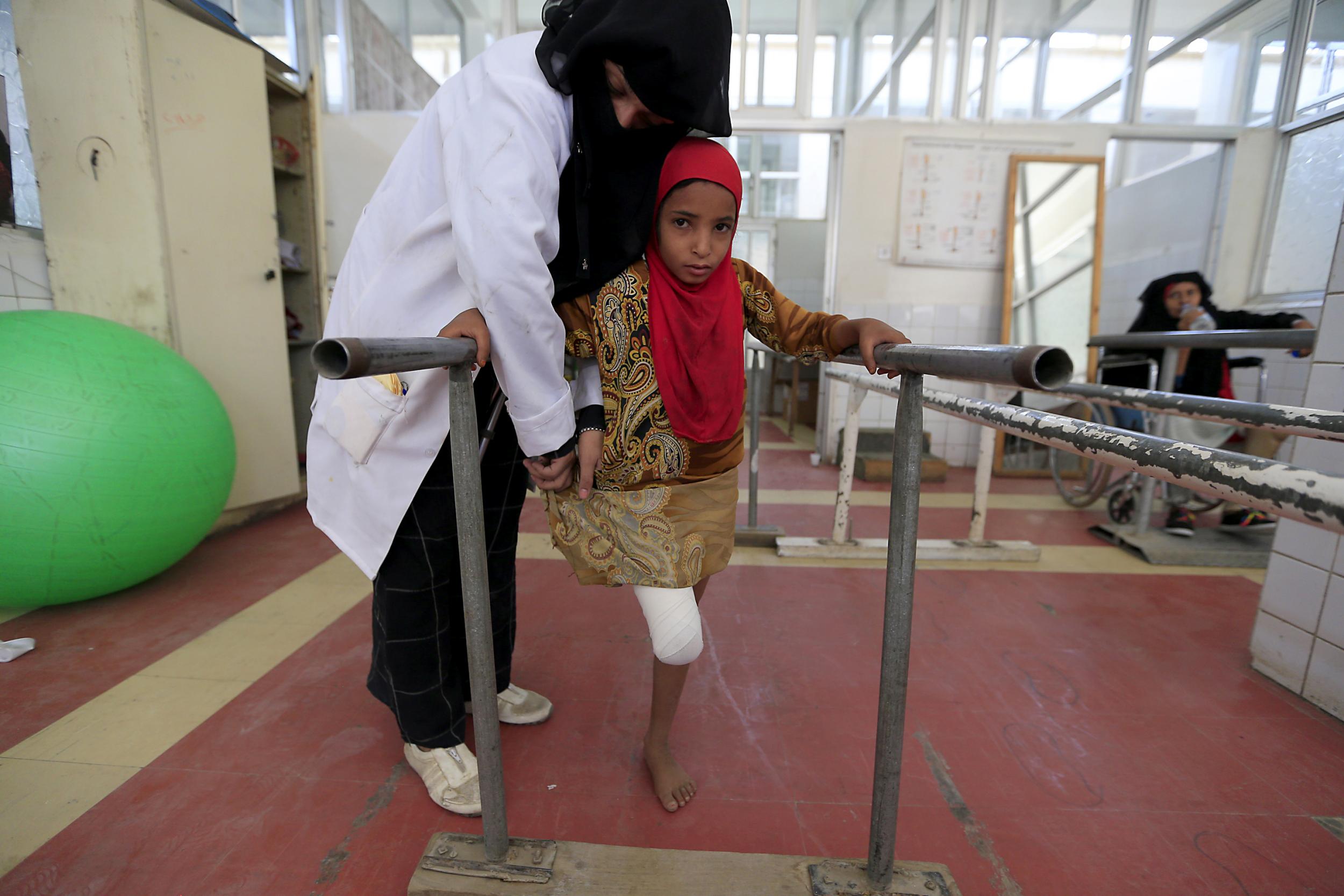 A wounded Yemeni girl exercises at a clinic for prosthetic limbs and physical rehabilitation in the capital Sanaa