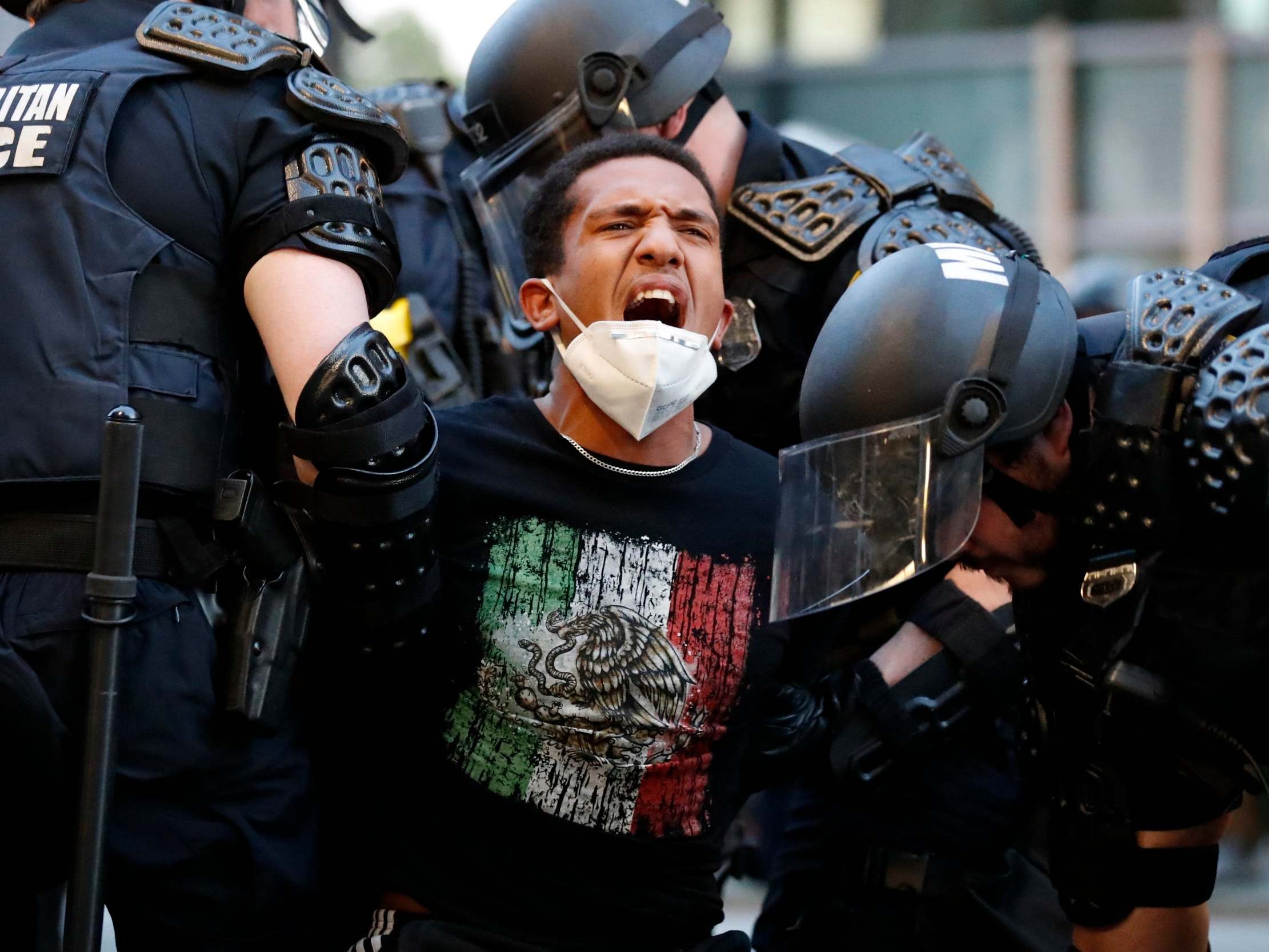 A demonstrator is taken into custody by police after a curfew took effect during a protest over the death of George Floyd, Monday, June 1, 2020, near the White House in Washington. 