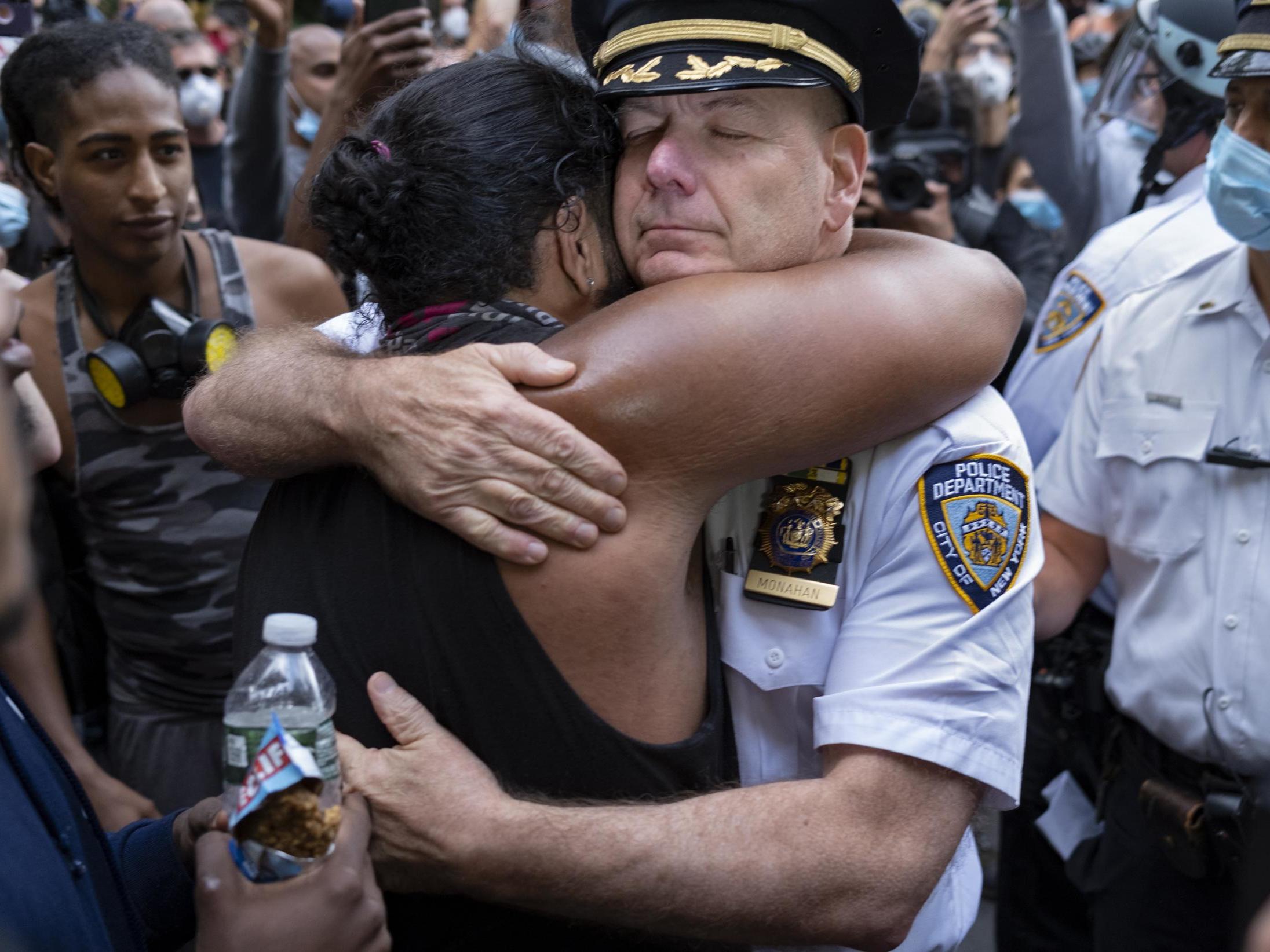 Chief of Department of the New York City Police, Terence Monahan, hugs an activist as protesters paused while walking in New York