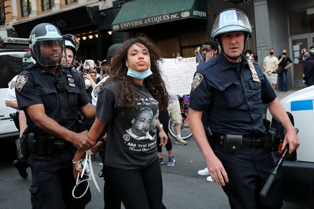 Police officers detain a demonstrator during a protest against the death in Minneapolis police custody of George Floyd, in the Manhattan borough of New York City