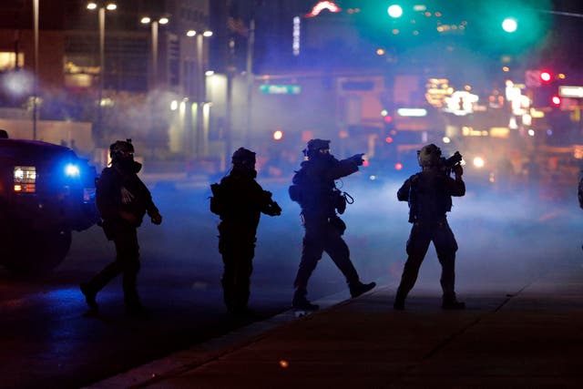Las Vegas police walk through tear gas during a protest after the death of George Floyd