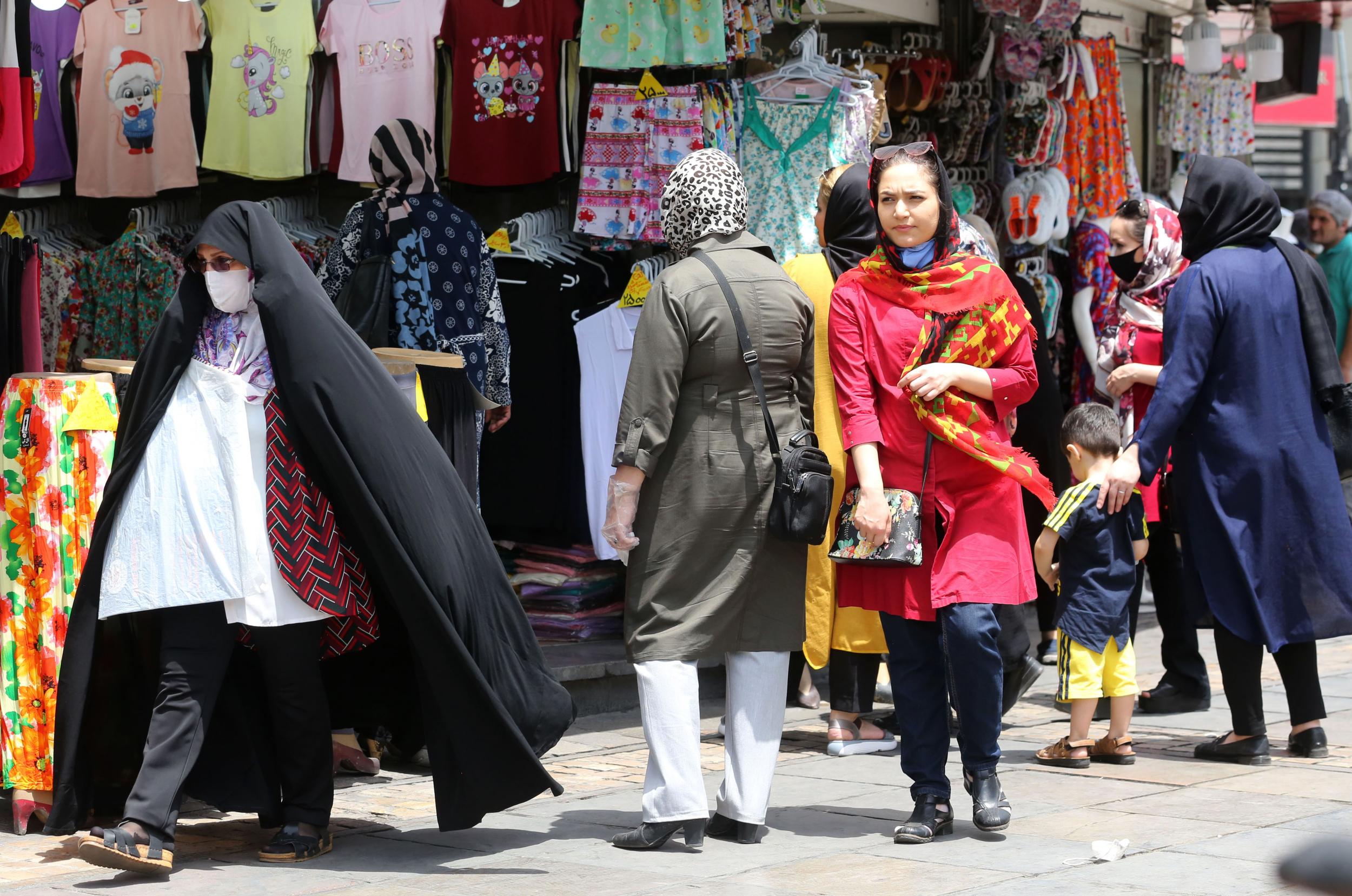 People shop in Tehran as officials say country is now ignoring social distancing rules