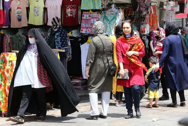 People shop in Tehran as officials say country is now ignoring social distancing rules 