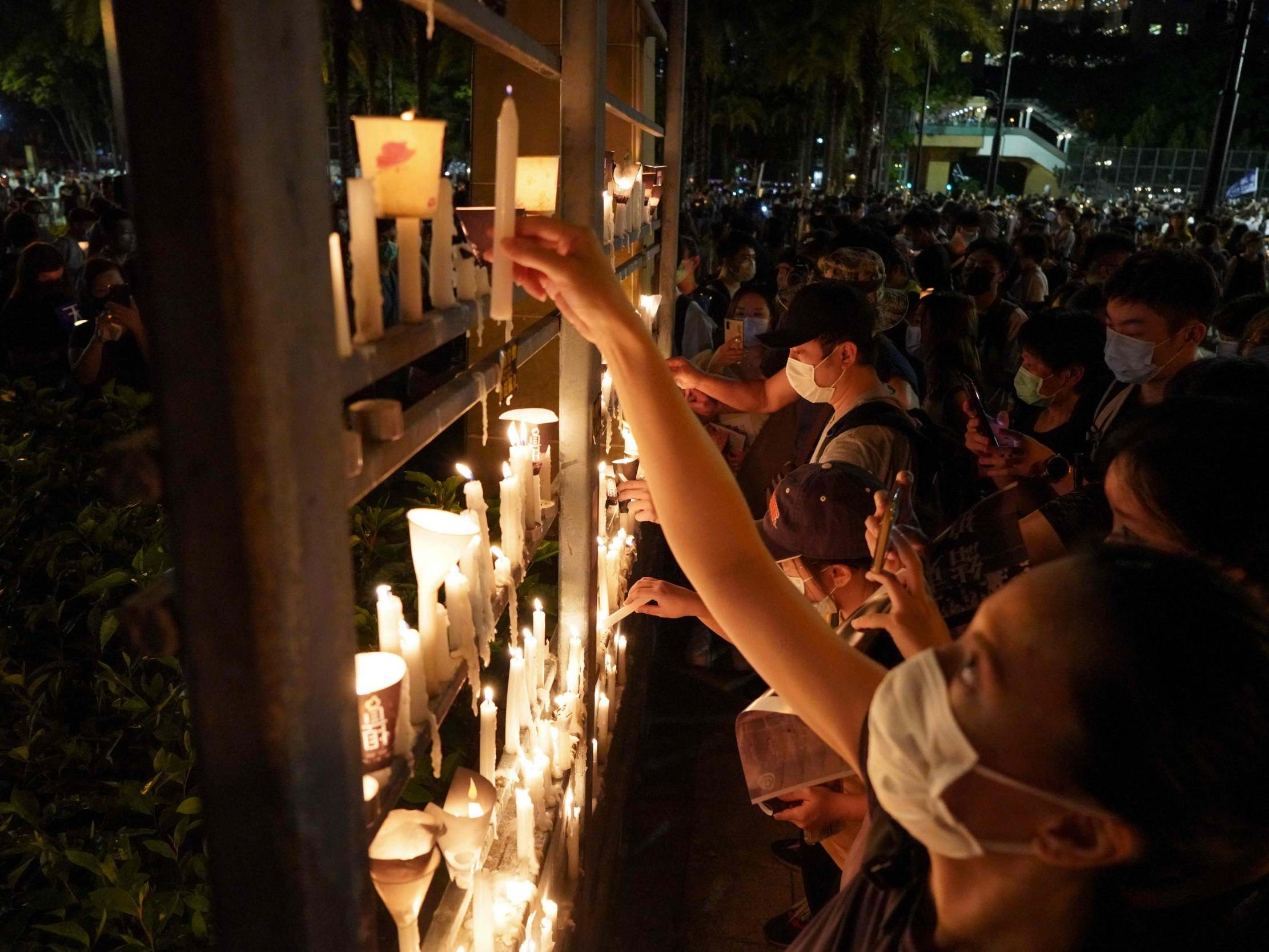 People light candles as they attend a vigil in Victoria Park in Hong Kong on June 4, 2020