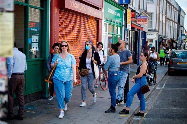 People queue outside a coffee shop in London