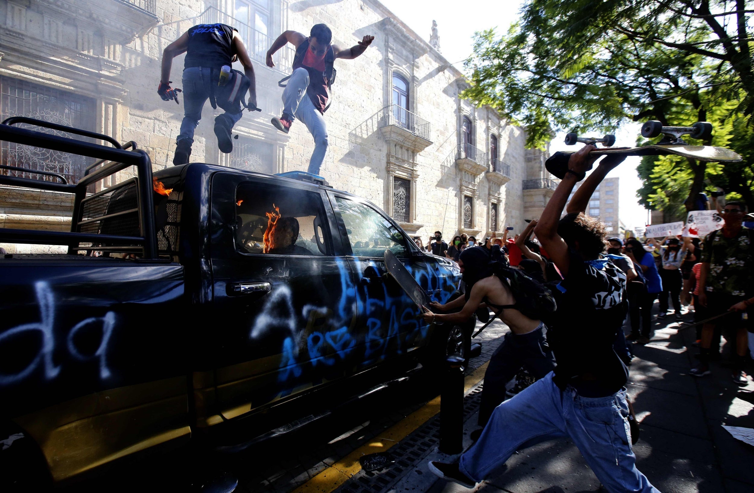 Demonstrators attack a police vehicle during a protest in Guadalajara