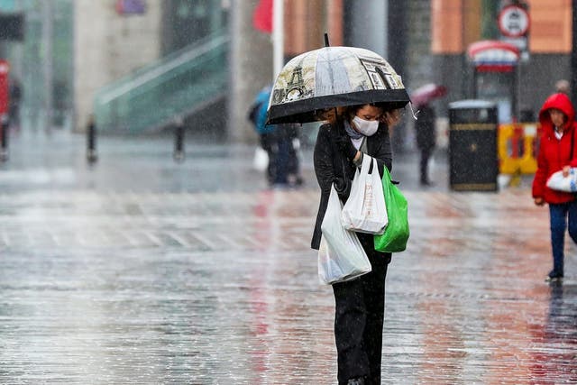 A shopper walks through the rain with an umbrella on 5 June, 2020.