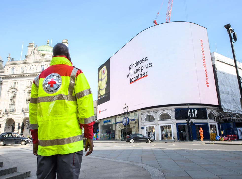 British Red Cross volunteer Emmanuel Cudjoe stands in front of the Piccadilly lights in London