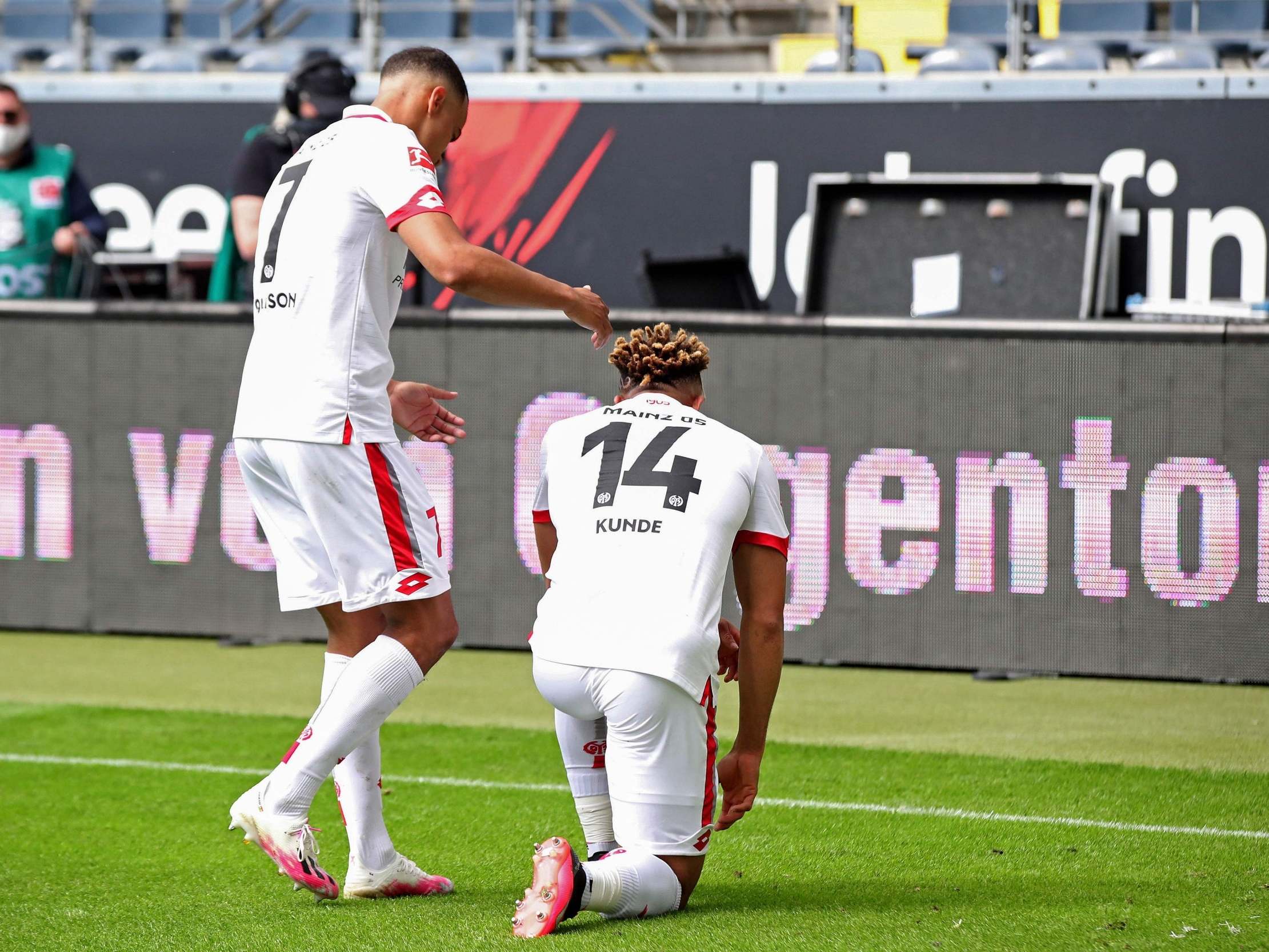 Mainz midfielder Pierre Kunde celebrates his goal by taking a knee