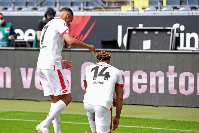 Mainz midfielder Pierre Kunde celebrates his goal by taking a knee