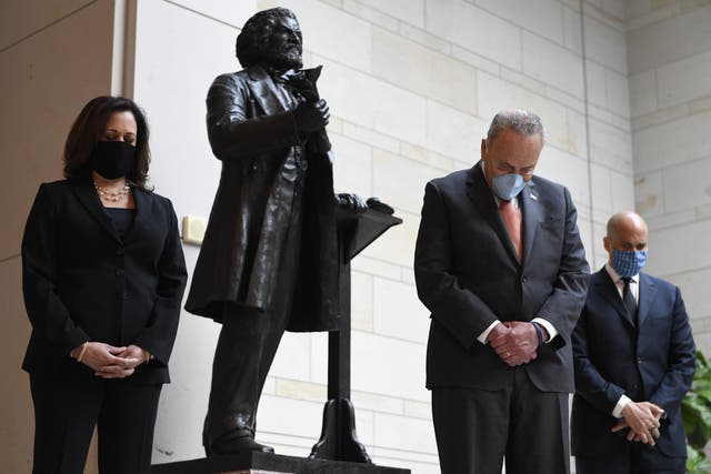Standing near a statue of Frederick Douglass, Senator Kamala Harris, left, Senate Minority Leader Chuck Schumer, centre, and Senator Cory Booker, right, pause during a prayer on Capitol Hill on Thursday
