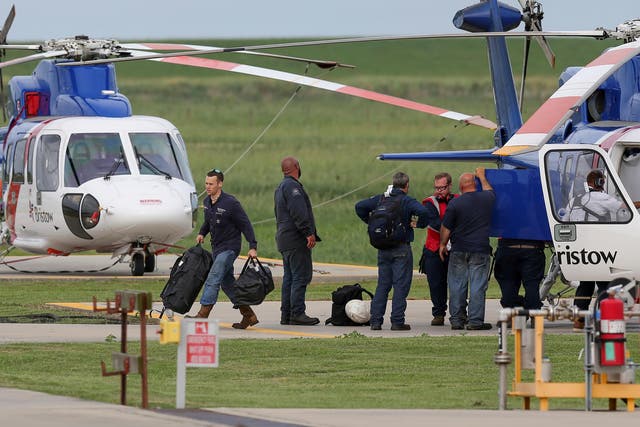 Workers disembark from a helicopter after being evacuated from oil production platforms ahead of Tropical Storm Cristobal, at Bristow Galliano Heliport in Louisiana