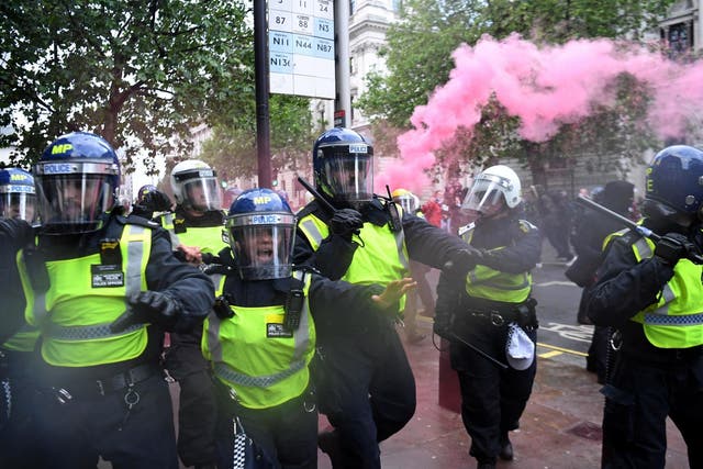 Police officers in riot gear shout to protestors near Downing Street on Saturday during a Black Lives Matter protest