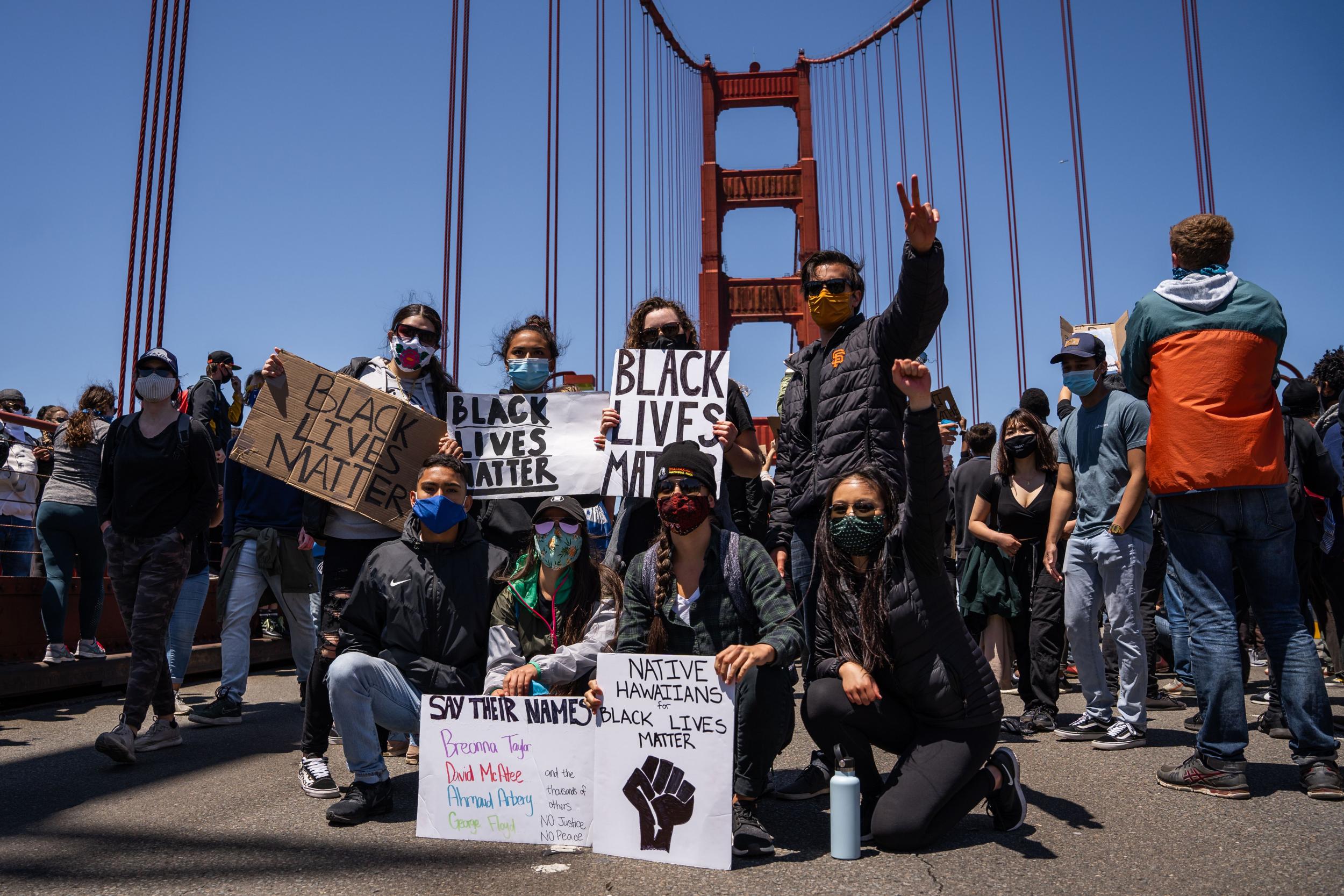 Protesters pose with Black Lives Matter signs on the Golden Gate Bridge during a demonstration against racism and police brutality