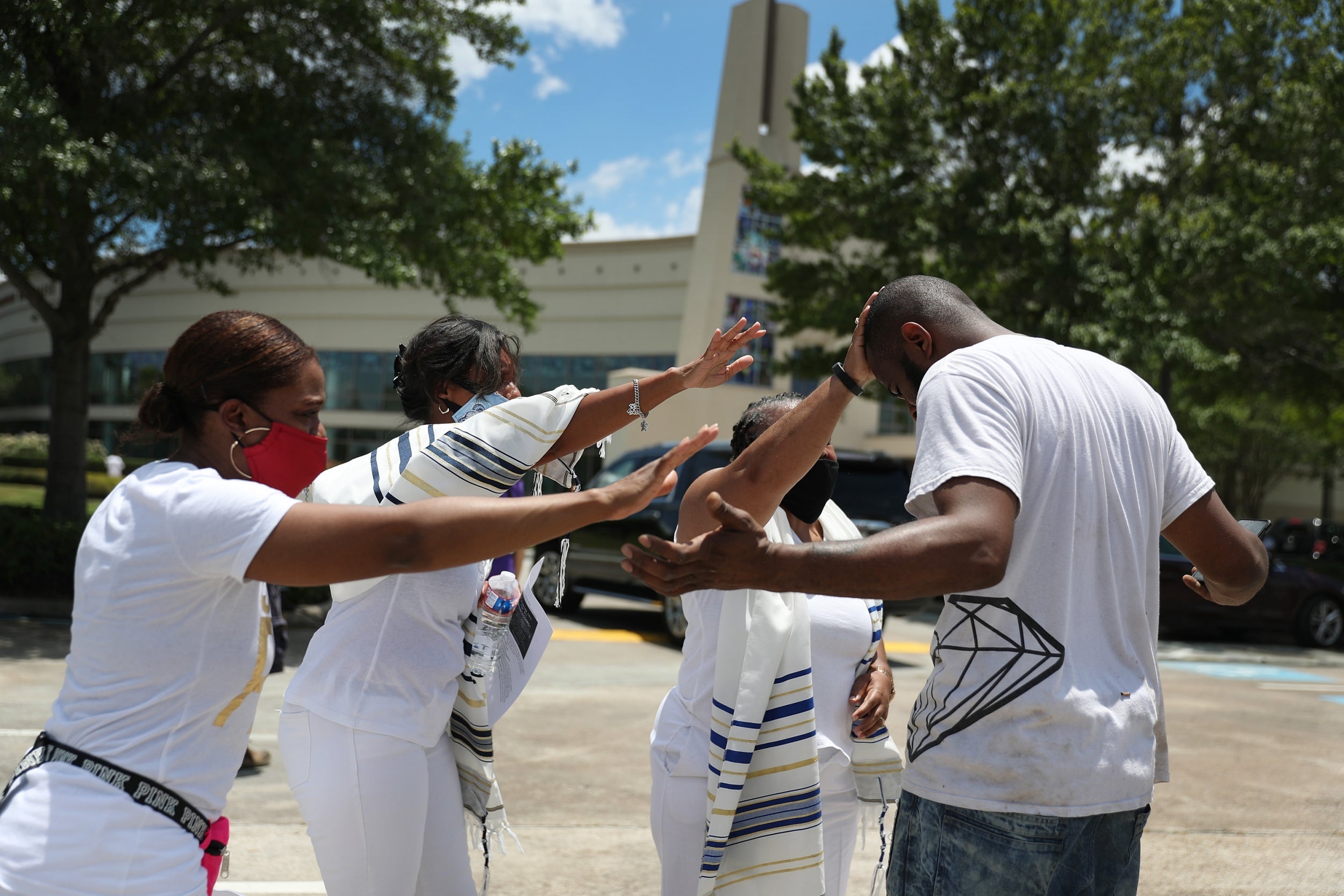 A group prays with Demitris Plair outside of the Fountain of Praise church where services will be held for George Floyd on June 7 in Houston, Texas. (Photo by Joe Raedle/Getty Images)