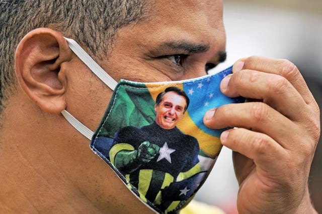 A Bolsonaro supporter wears a face mask with the president's image during a demonstration in Rio de Janeiro