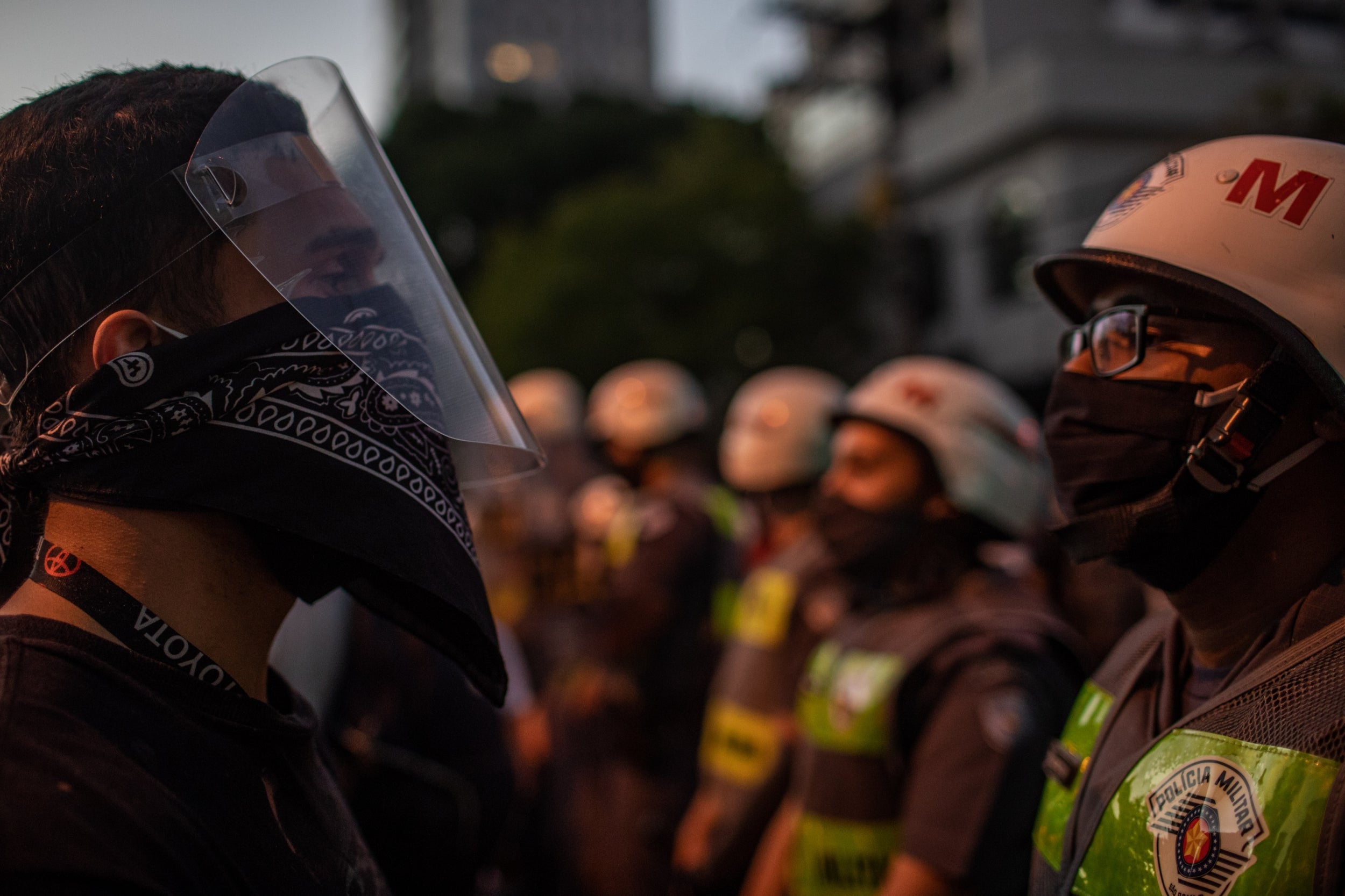 Pro-democracy protesters face off with military police during a protest against Bolsonaro