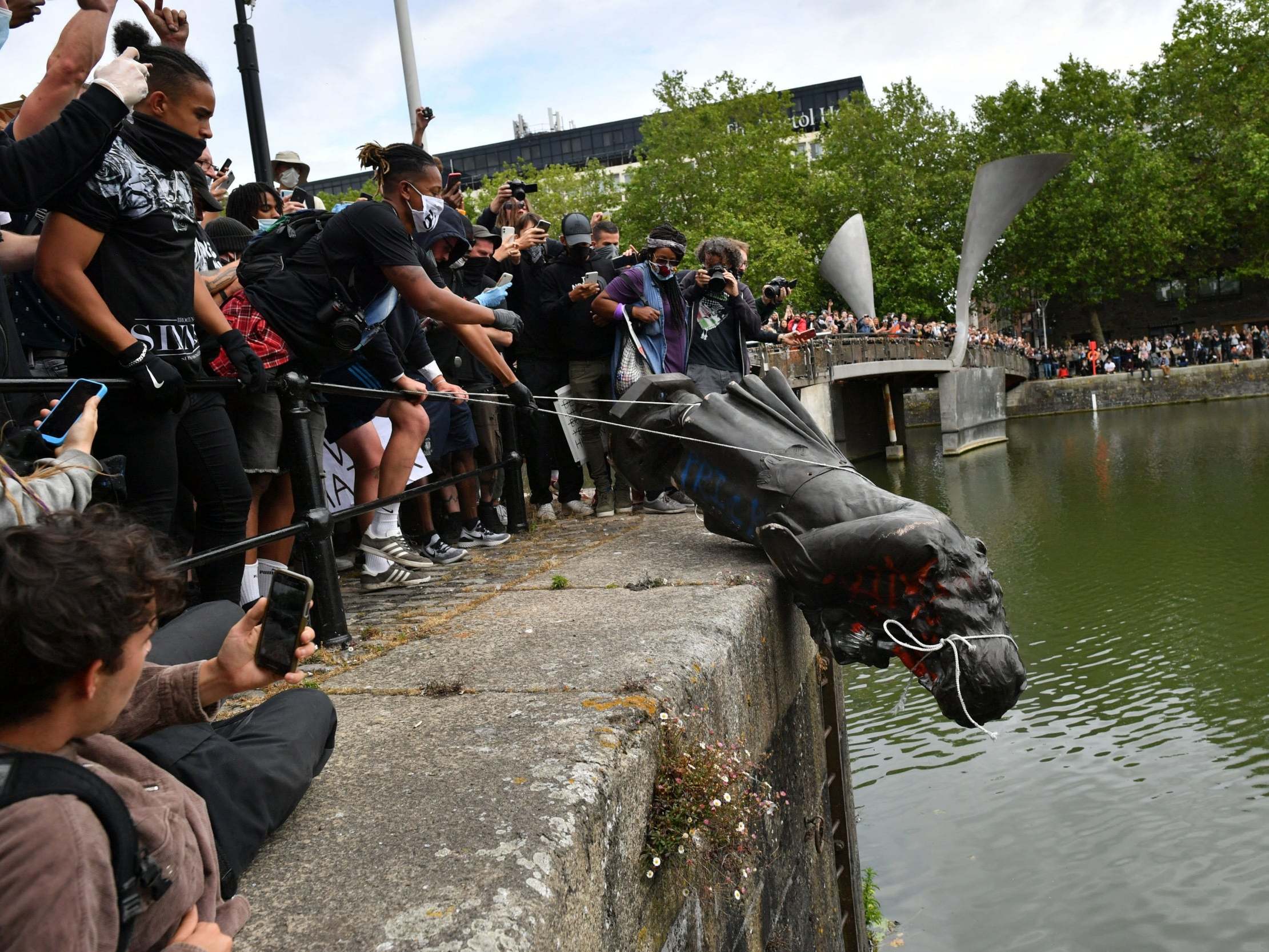 Protesters throw statue of Edward Colston into Bristol harbour during a Black Lives Matter protest rally, 7 June 2020. (Ben Birchall/PA)