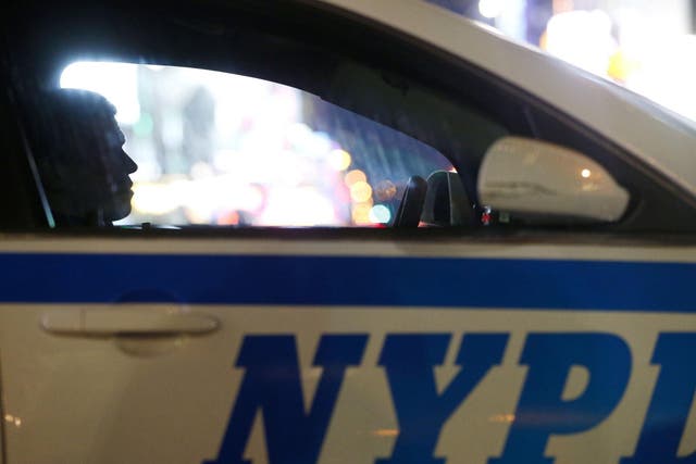 A New York City police officer sits in a cruiser at a checkpoint surrounding Times Square