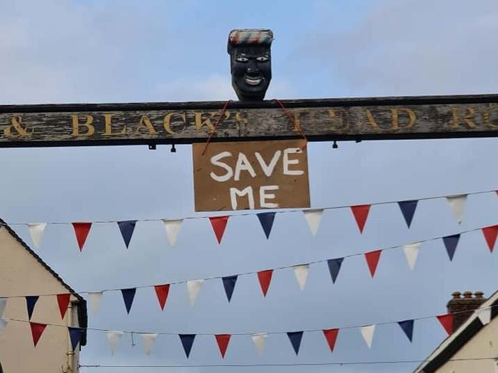 A sign saying 'Save Me' was hung from the controversial head in Derbyshire on Monday evening before it was taken down