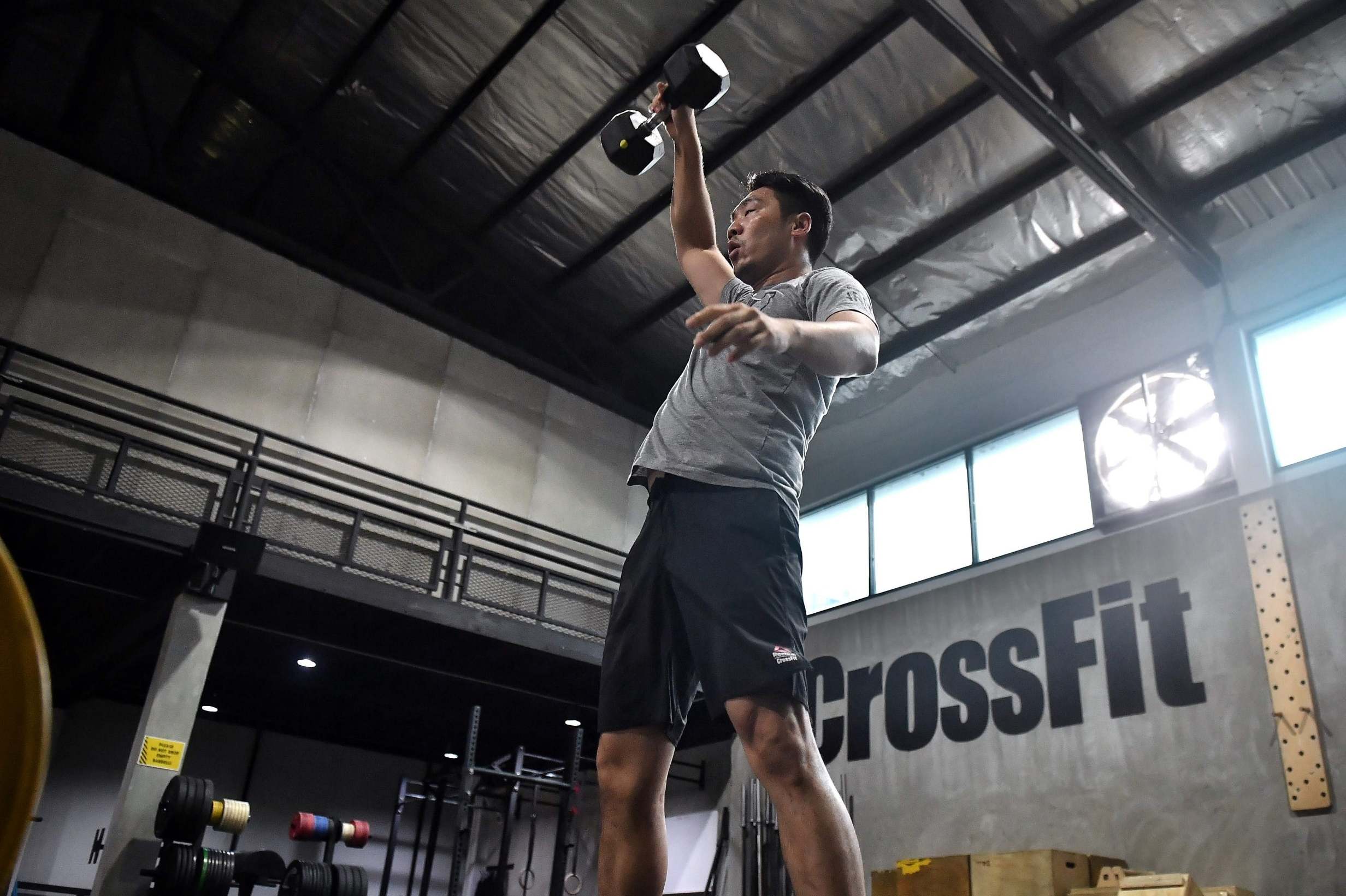 A gym enthusiast exercises while adhering to social distancing guidelines at CrossFit Arena Bangkok