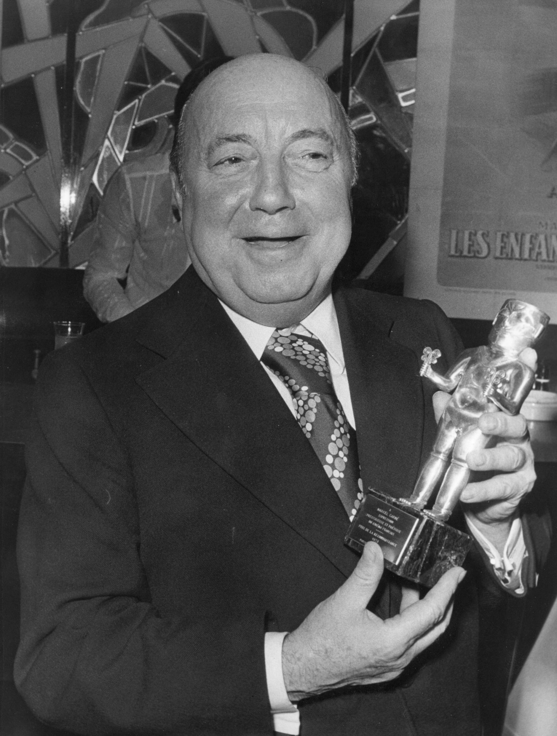 Marcel Carné poses with the Prix de la Reconnaissance awarded in recognition of his work